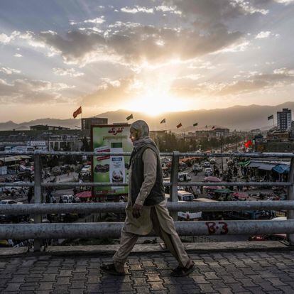 A man walks over a bridge in Kabul on August 7, 2022. (Photo by Lillian SUWANRUMPHA / AFP)
