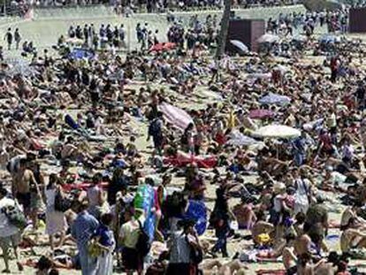 Playa de Barcelona abarrotada de gente. PLANO GENERAL - ESCENA