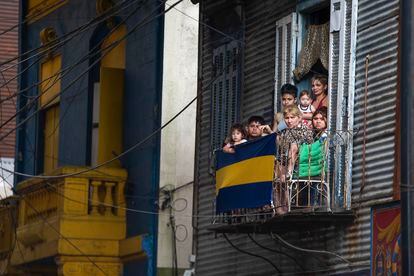 Una familia se asoma al balcón de su casa de chapas tras enterarse de la muerte de Diego Maradona, a metros de La Bombonera, en el barrio de La Boca.