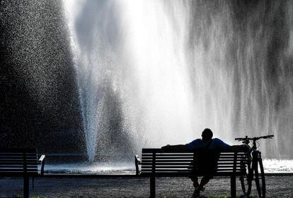 Un hombre se refresca durante una jornada de altas temperaturas en el parque Tessin en Estocolmo (Suecia).