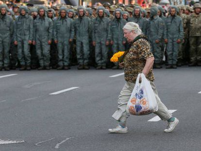 Una mujer cruza una calle frente a un cordón de militares, el lunes en el centro de Kiev.