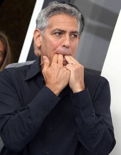 George Clooney silba en el posado ante los fotógrafos en Venecia.