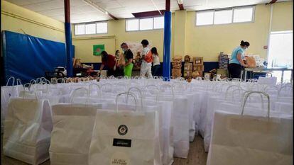 Varios voluntarios preparan en el gimnasio los lotes para las familias que acudían a por comida al Colegio Ramón María Del Valle-Inclán durante el confinamiento.