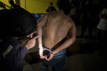 Un oficial de policía inspecciona los tatuajes de José Alexander Carranza, miembro de la Mara Salvatrucha, que se encuentra actualmente en tregua con su rival, La 18. La dos bandas son responsables de gran parte de los asesinatos y del narcotráfico en Honduras.