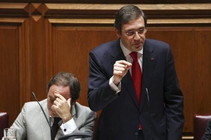 Pedro Passos Coelho (de pie), junto al ministro de Exteriores, Paulo Portas, en el  debate del Estado de la Naci&oacute;n.