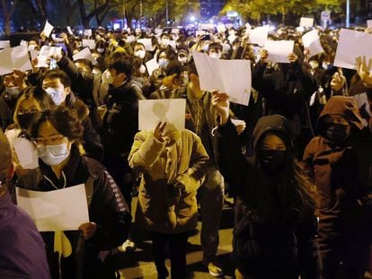 Manifestantes contra la política de covid cero, con folios en blanco en la mano, en Pekín.