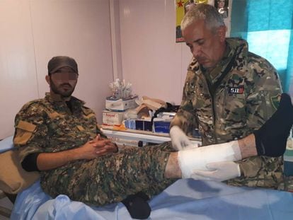 El Doctor Delil atendiendo a un miliciano kurdo herido en su dispensario del campamento de Ahmud, en Sinjar (Irak).