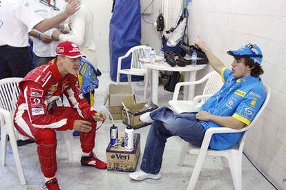 Michael Schumacher y Fernando Alonso conversan antes de la carrera.