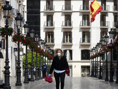 Una mujer con mascarilla recorre la calle Larios de Málaga.
 
 