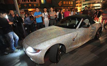 Curiosos observan un coche salpicado de diamantes en Shengyang.