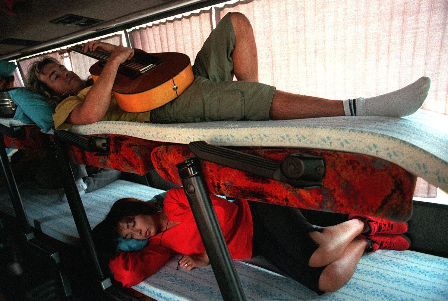 La cantante María Ángeles Muñoz (abajo) y el guitarrista del grupo Camela, en el autocar que usa el grupo para las giras de verano, en 2000.