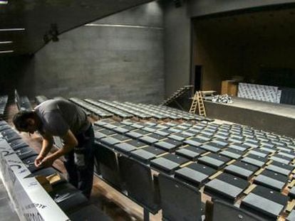 Un operario da los &uacute;ltimos retoques a las butacas del auditorio del centro Garc&iacute;a Lorca en Granada. 