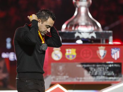 Xavi Hernández quitándose la medalla de segundo lugar después de la final de la Supercopa.