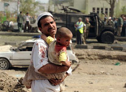 Un afgano lleva en brazos a su hijo herido en el lugar de la explosión.