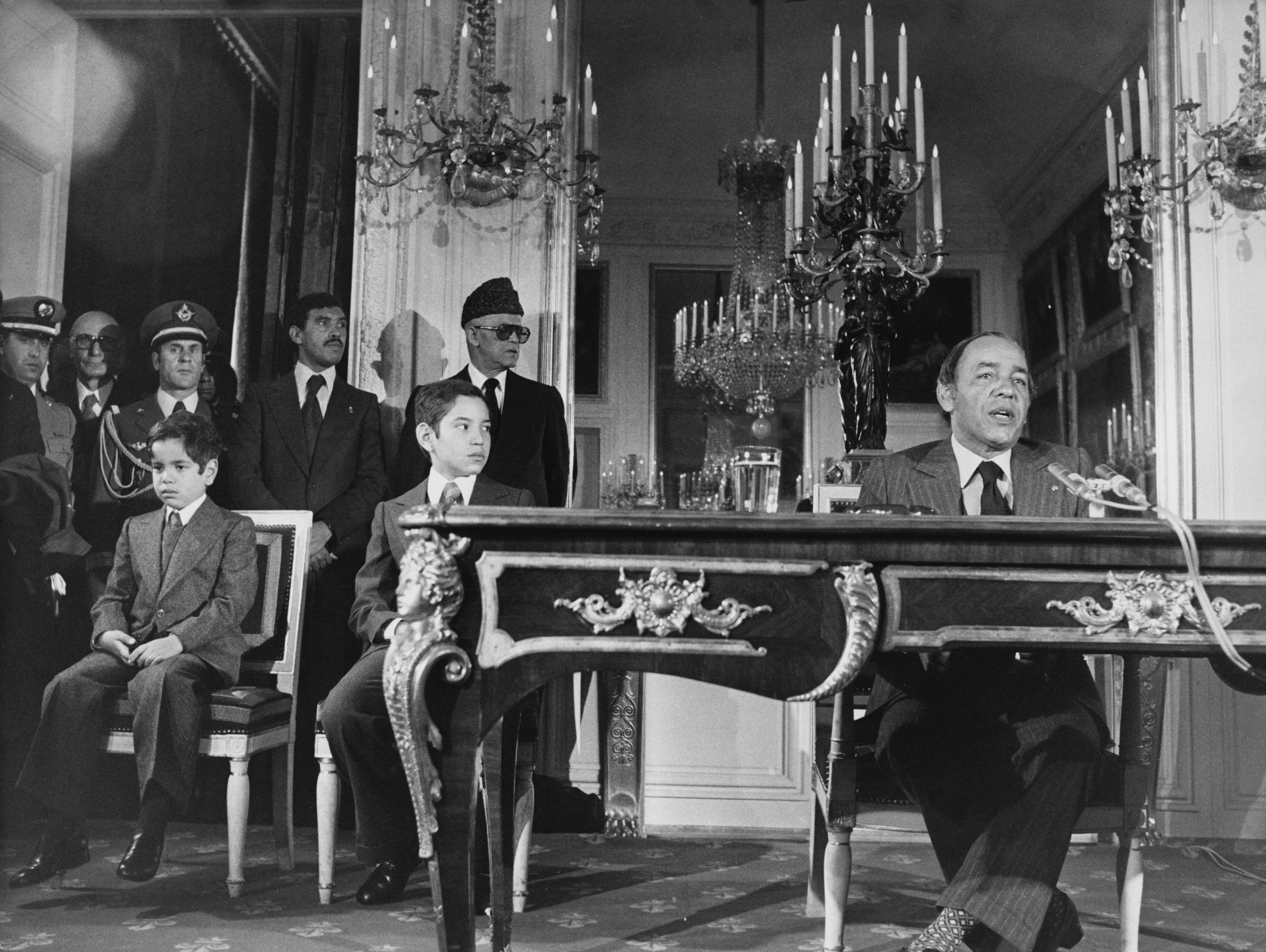 El rey Hassan II ofrece una conferencia de prensa cerca del palacio de Versalles, durante una visita oficial a Francia, el 25 de noviembre de 1976. A su derecha, los príncipes Mohamed y Rachid.