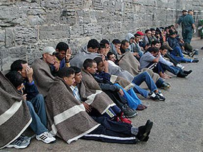 Un grupo de inmigrantes se tapa con mantas tras su llegada ayer al puerto de Tarifa (Cádiz).