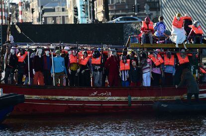 Activista de Amnistía Internacional en un barco lleno de maniquíes con chalecos salvavidas como protesta contra la crisis de los refugiados antes de la reunión informal de ministros europeos de Justicia e Interior en el museo marítimo de Amsterdam.