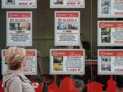 Una mujer mira el escaparate de una agencia inmobiliaria en Madrid.
