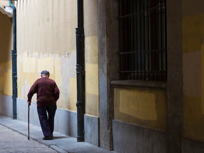 Un anciano camina con su bastón en Ávila.