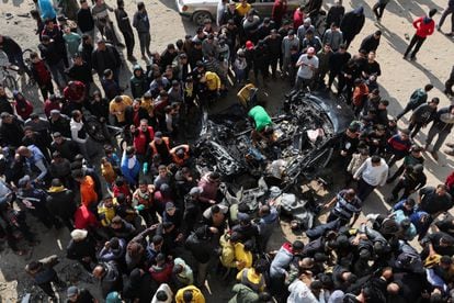 Un grupo de gazatíes observa los restos de un automóvil destruido durante un ataque israelí, este sábado en Gaza.