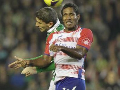 Brayan Angulo salta con Salva Sevilla durante un partido del Granada ante el Betis