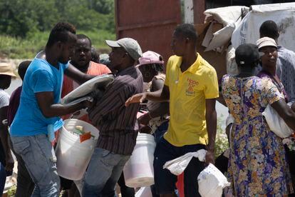 Dos personas disputan una manta durante el saqueo de un camión de ayuda humanitaria en Maniche. 