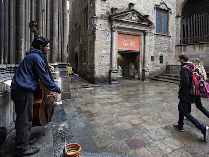 Un home toca un contrabaix enfront del museu Frederic Mares a Barcelona.