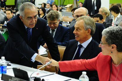 El primer ministro palestino, Salam Fayyad, saluda a la enviada de EE UU a Oriente Próximo, Mara Rudman, en presencia de Tony Blair.