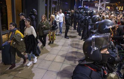 Los 'mossos' protegen a los viajeros que quieren acceder a la estación de Sants, en Barcelona. 