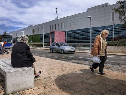 Usuarios del transporte p&uacute;blico esperan la llegada del autob&uacute;s en el hospital universitario Son Espases, en Palma.