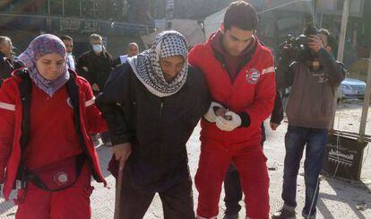 Empleados de la Media Luna Roja evacúan a un rafugiado palestino.