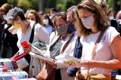 Había hambre de Sant Jordi y se ha notado desde primera hora de la mañana en Barcelona, con miles de personas haciendo cola pacientemente para acceder a los puestos de libros y rosas. En la imagen, varias personas hojean libros, en el parque de la Devesa de Girona.