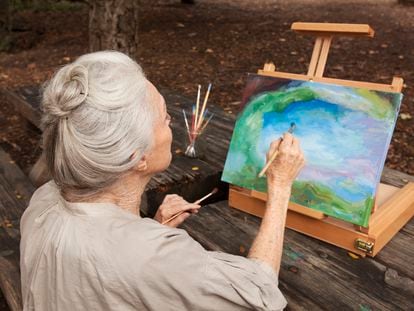 Una mujer pinta un cuadro en el parque. La literatura científica asegura que cultivar aficiones como la pintura es beneficioso para la salud.