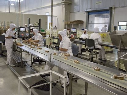 Trabajadores empaquetan chocolates en la línea de producción de la Compañía Nacional de Chocolate de Grupo Nutresa, en Medellín (Colombia) en junio de 2017.