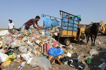 Un hombre descarga materiales de deshecho en un basurero a las afueras de Hyderabad.