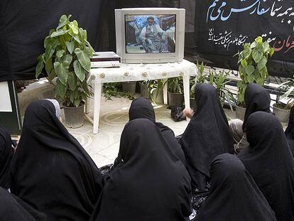 Mujeres iraníes ven en televisión una ceremonia del aniversario de la muerte de Jomeini.