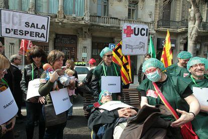 Manifestantes vestidos de enfermos escenifican la situación de las administraciones tras el recorte de la Generalitat.