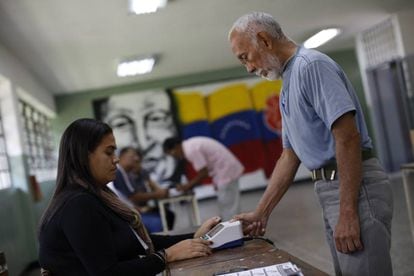 Un hombre coloca su pulgar en una máquina de identificación en una mesa electoral durante la elección de la Asamblea Constituyente en Caracas.