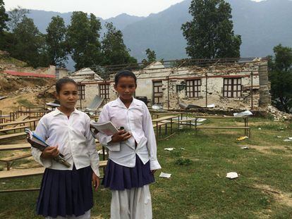 Dos niñas pasan por lo que era su escuela, en Chokati Lato una aldea del distrito de Sindhupalchowk. Las aulas temporales en este lugar están en proceso de construcción. Un millón de los 8,5 millones de estudiantes matriculados en primaria y secundaria en Nepal se quedó sin aulas.