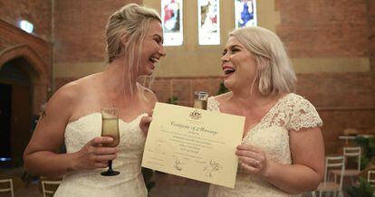 Sarah Turnbull (izquierda) y Rebecca Hickson (derecha) con su certificado de matrimonio después de casarse el lunes en Newcastle (Australia).