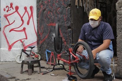 Jhoan Martín Machado repara una bicicleta en las calles de Quito (Ecuador), uno de los trabajos informales que realiza desde que llegara al país.
