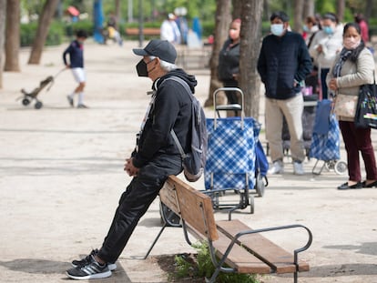 Vecinos de Aluche hacen cola para recoger alimentos, en abril de 2021 en Madrid.