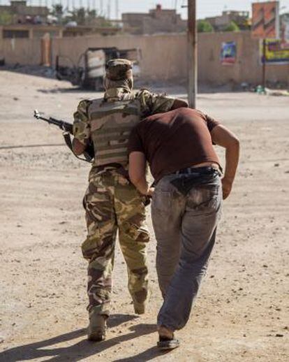 Un soldado detiene a un sospechoso en Kerbala.