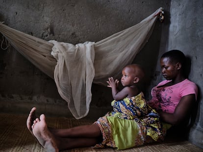 Alinafe posa para un retrato mientras sostiene en brazos a su hija Tamanda, de 15 meses, a la cual todavía da de mamar en el burdel donde trabaja.