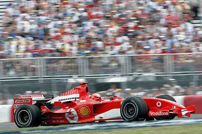 Michael Schumacher pasa delante de unas gradas teñidas de rojo.