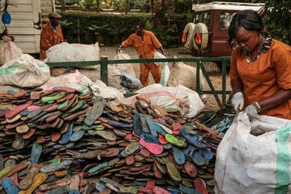 Empleados de Ocean Sole abren sacos con chancletas usadas procedentes de Nairobi y la costa de Kenia.