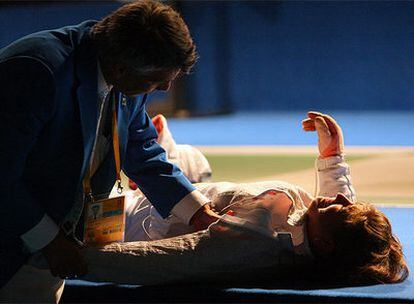 La española Araceli Navarro es atendida por un médico antes de retirase de la competición de dieciseisavos de final de sable individual de esgrima femenina