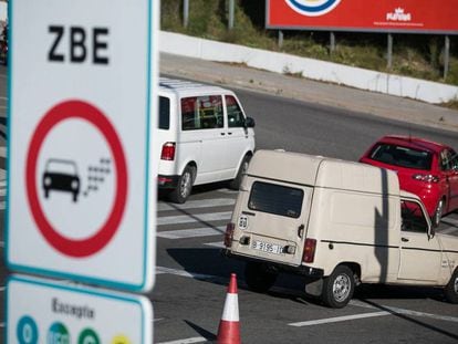 Un coche contaminante pasa por delante de un indicador de la ZBE en L'Hospitalet de Llobregat, la semana pasada. En vídeo, los cambios que estrena Madrid Central y la nueva zona de bajas emisiones en Barcelona.