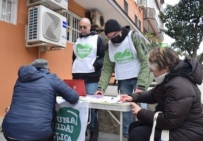 Dos voluntarios de la Asamblea Popular de Carabanchel recogen quejas de los pacientes que no han logrado conseguir una cita con su médico.