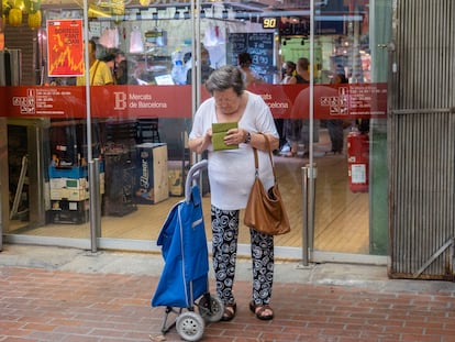 Una mujer revisa su monedero a la salida del mercado de Hostafrancs, en Barcelona.